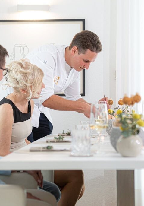 Ein private cooking Event, bei dem der Chef-Caterer Daniel gerade die Gäste mit Essen vom Feinsten versorgt